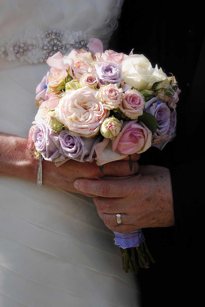 Mariage - Gros plan du bouquet de mariage tenu par un couple âgé.
