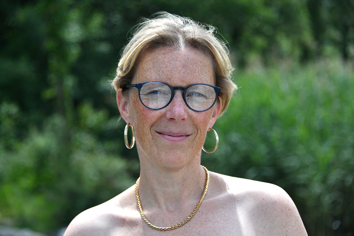 Portrait de Christelle vue de face avec montures bleues.