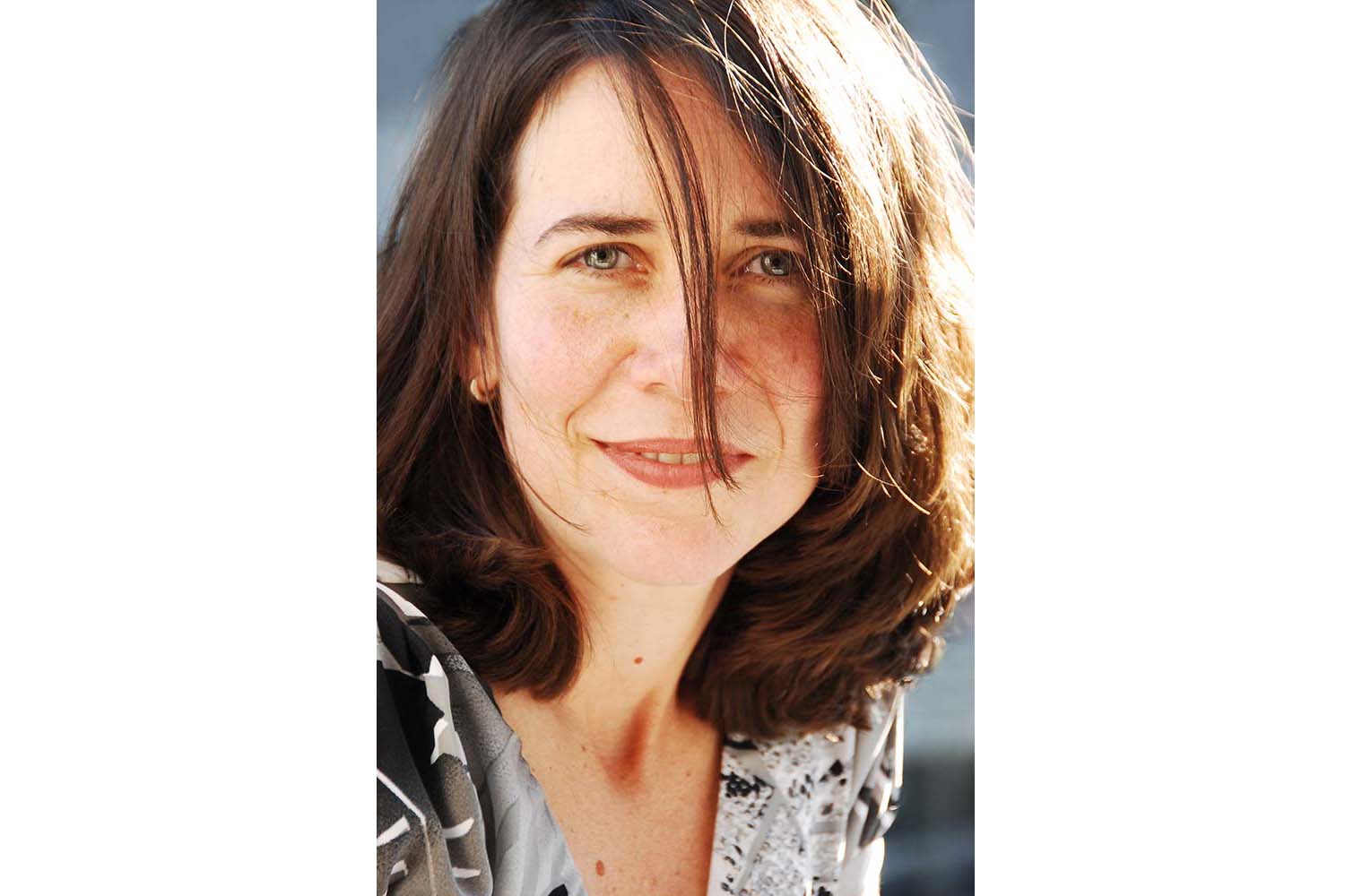 Portrait photographie d'Andrea avec cheveux bruns ondulés.